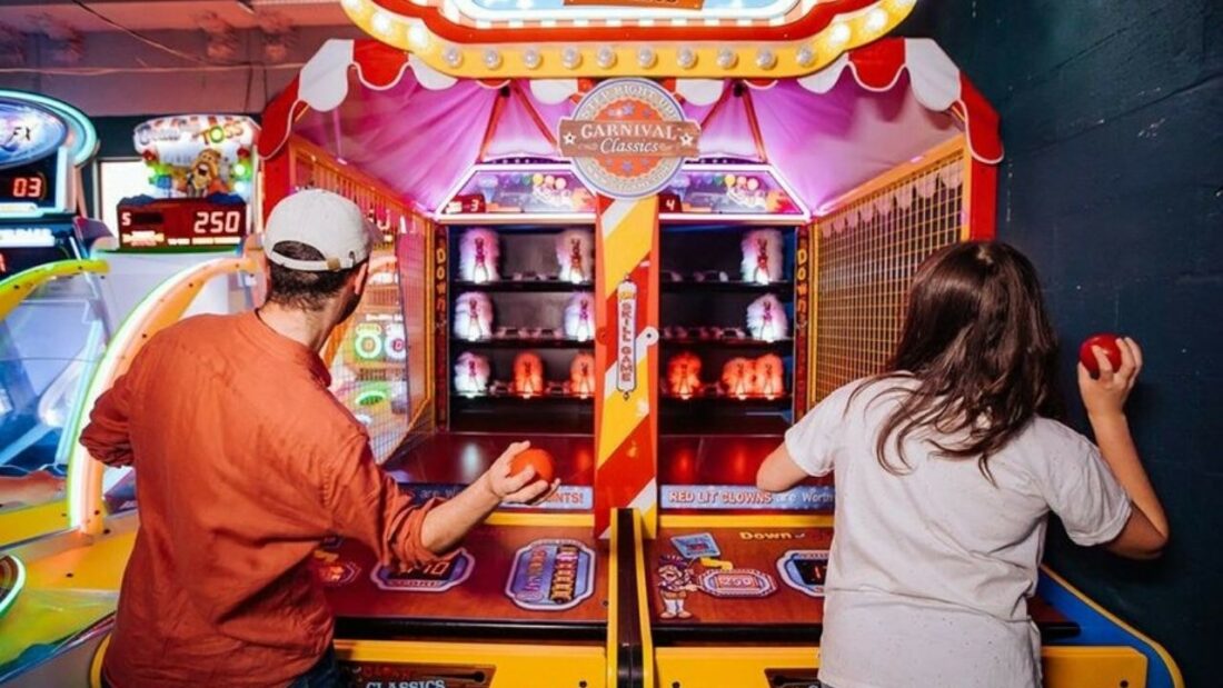 Friends playing classic arcade games at B Lucky & Sons