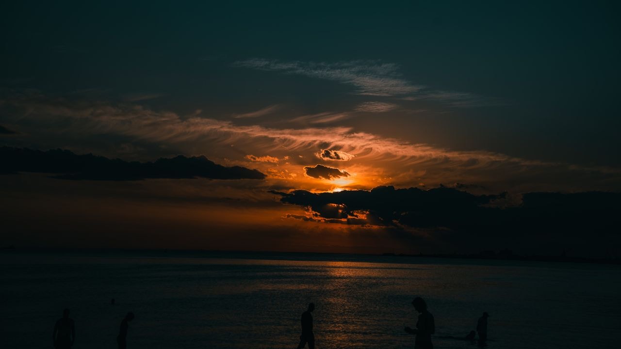 Beachgoers at sunset in Melbourne, ideal for team-building activities