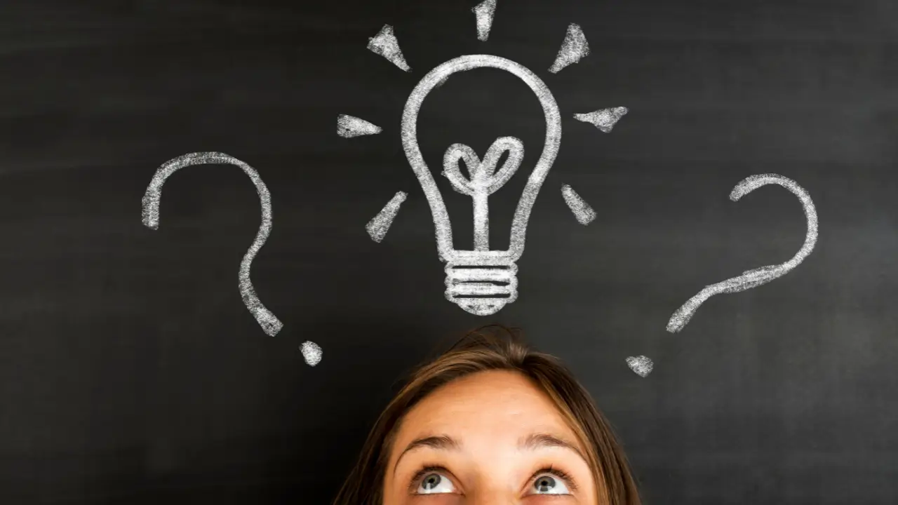 A woman, with only her eyes visible, looking up at a light bulb, representing having an idea.