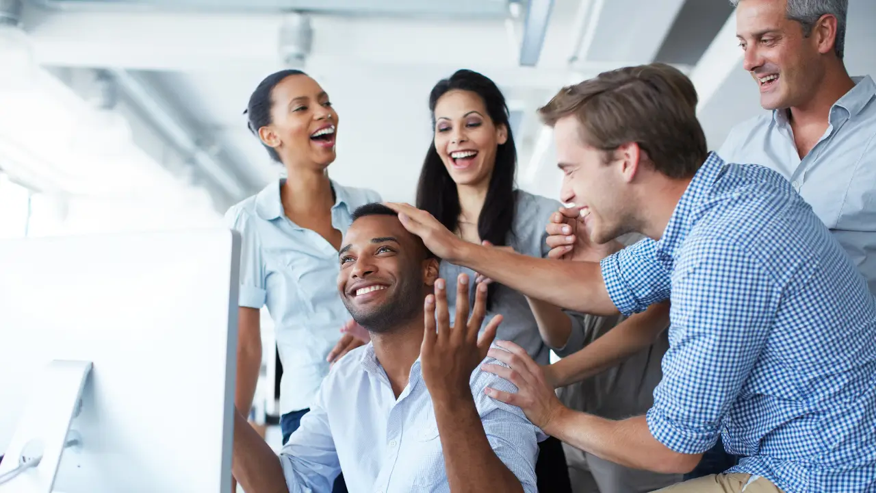 An employee being praised by his colleagues for doing a good job.