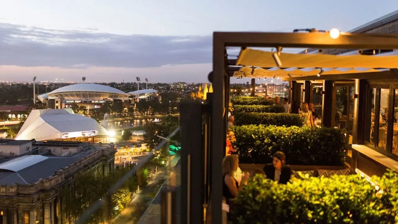 Elegant rooftop bar in 2KW Adelaide overlooking the city skyline, ideal for drinks under the stars.