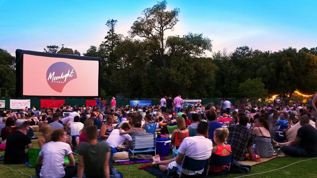  Outdoor cinema in Adelaide Botanic Garden, filled with people on a balmy night, ideal for watching movies