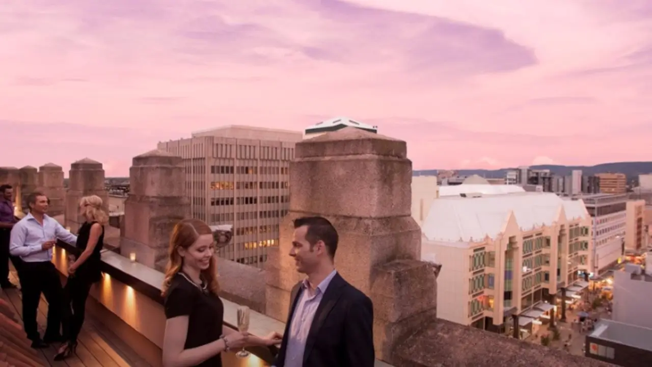 Patrons at the HENNESSY Rooftop Bar enjoying evening drinks with a view of Adelaide’s skyline