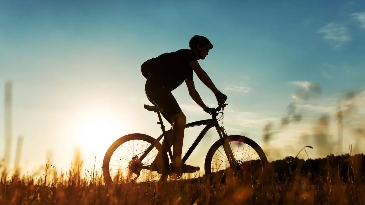 Solo rider on a mountain biking adventure at sunset through the rugged terrains