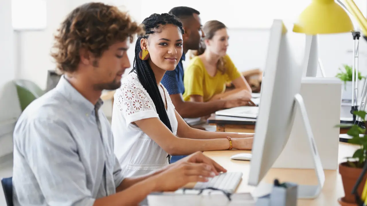 Students in front of computers, practicing their hard skills in computer literacy and software programs.