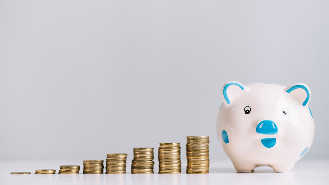 Piggy bank with stack of coins on its side