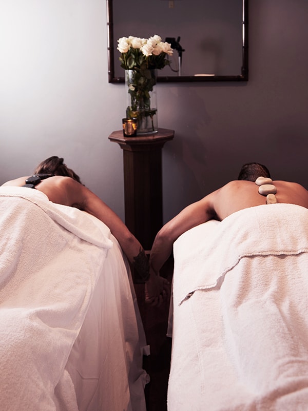 Two adult relaxing in hot stone massage