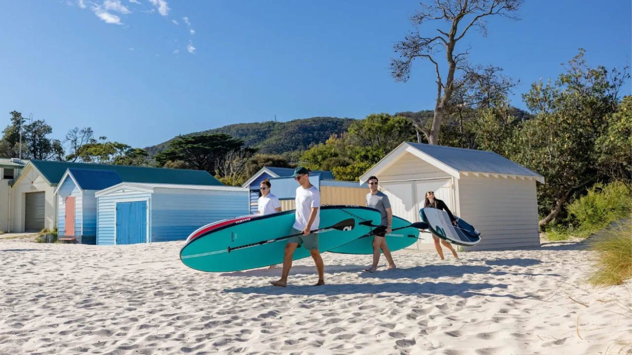 A pristine beach with surfboards and beach huts