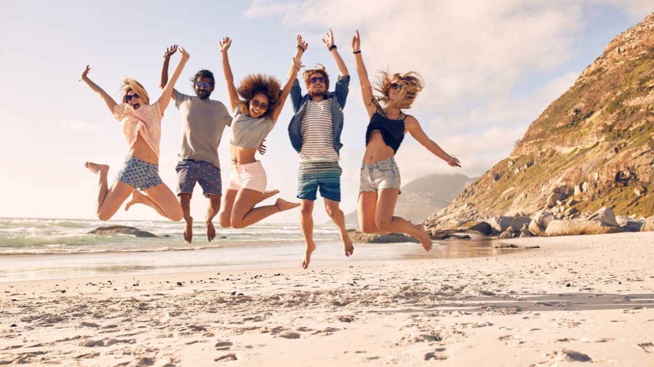 A jump shot of friends on a perfect beach day